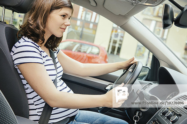 Schwangere Frau beim Autofahren