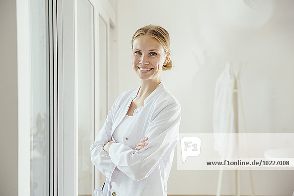 Portrait of smiling female doctor with arms folded