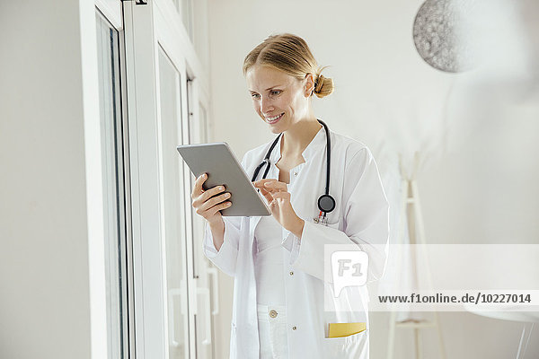 Smiling female doctor using digital tablet