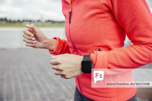 Young woman jogging with smart watch