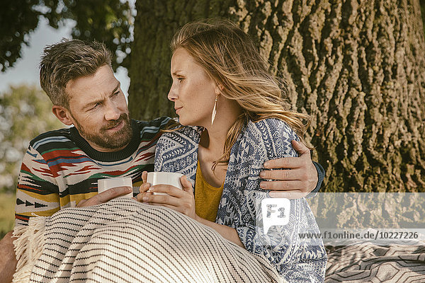 Paar mit einem Heißgetränk im Freien
