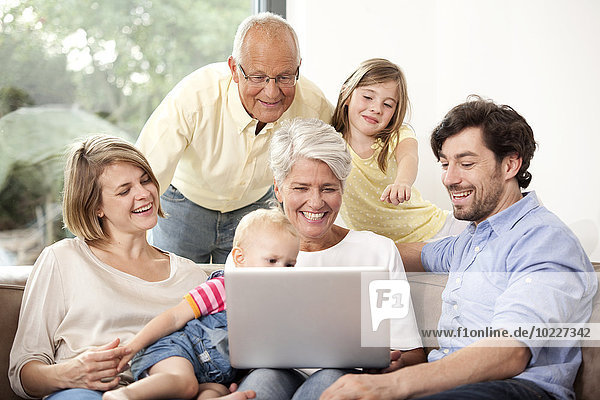 Erweiterte Familie auf der Couch mit Laptop