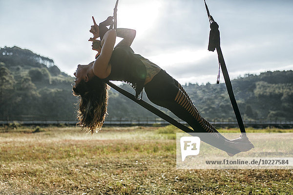 Spanien  Asturien  Villaviciosa  Frau beim Aerial Yoga im Freien