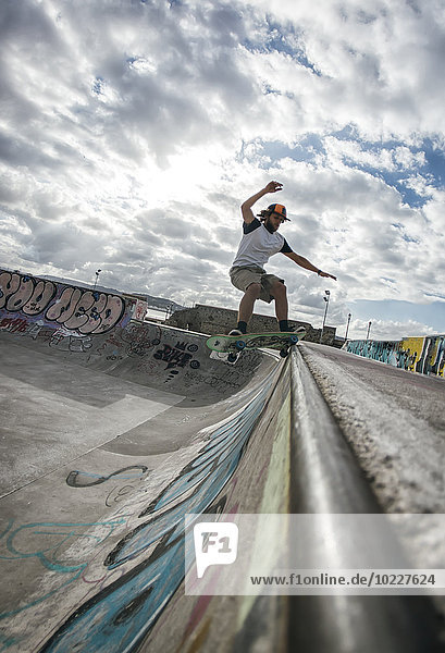 Junger Mann beim Skateboarden im Skatepark