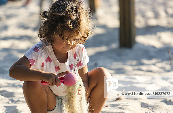 Kleines Mädchen spielt im Sandkasten auf dem Spielplatz