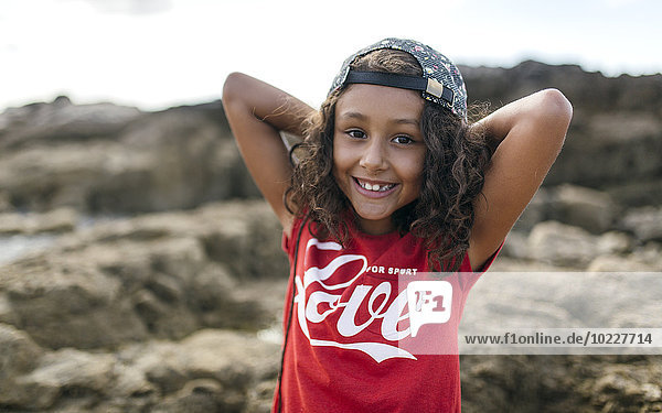 Spain  Gijon  portrait of smiling little girl at rocky coast