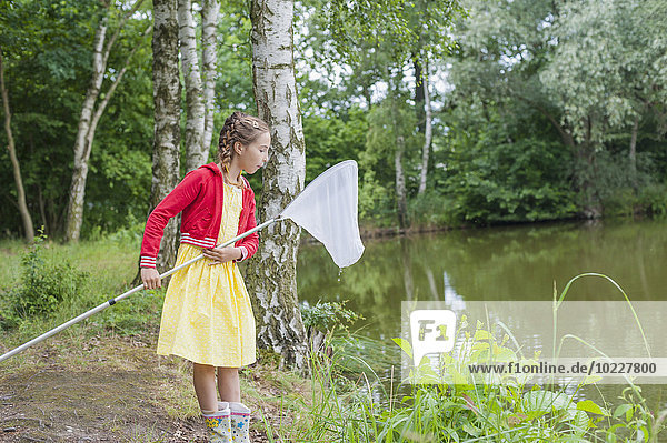 Deutschland  Mädchen mit Fischernetz am Teich