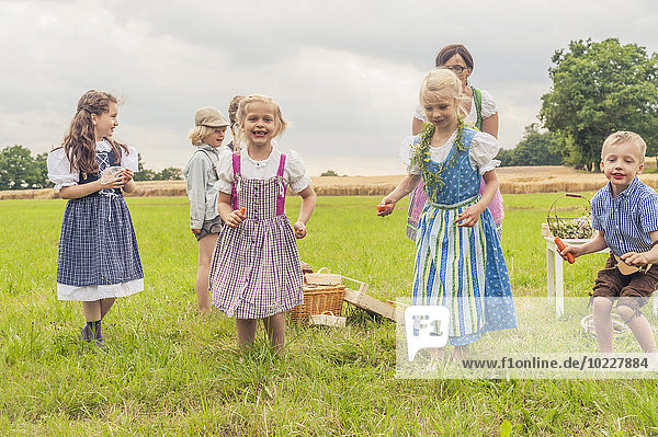 Germany  Saxony  children in traditonal clothes dancing on a meadow