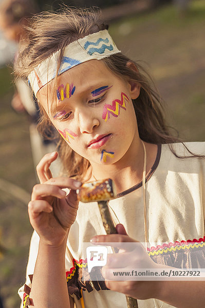 Deutschland,  Sachsen,  Indianer und Cowboy Party,  Mädchen mit gebratenem Marshmallow am Stiel