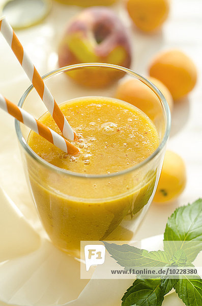 Pfirsich-Aprikosen-Smoothie im Glas mit Trinkhalm
