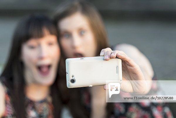 Zwei glückliche junge Frauen  die einen Selfie nehmen.