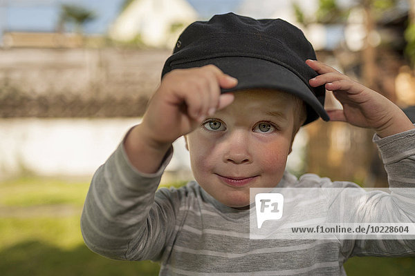 Porträt eines kleinen Jungen mit passender Mütze eines Erwachsenen