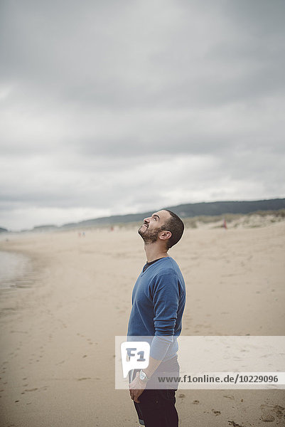 Spain  Ferrol  man standing on the beach looking up
