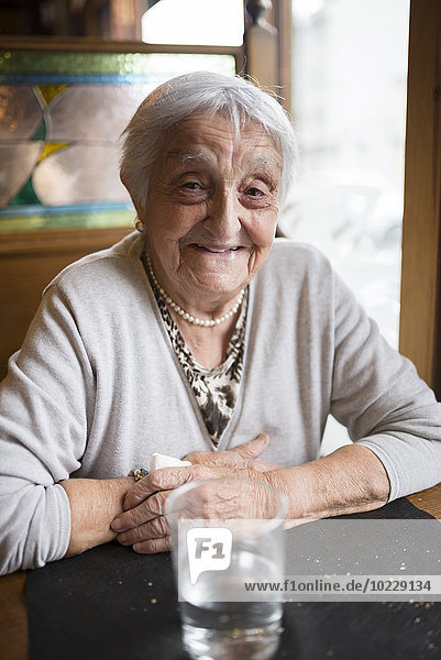 Portrait of smiling senior woman sitting in a restaurant