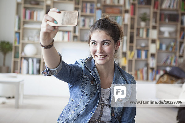 Junge Frau nimmt einen Selfie mit Smartphone mit nach Hause