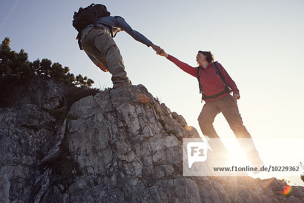 Austria  Tyrol  Unterberghorn  man helping woman on hiking trip
