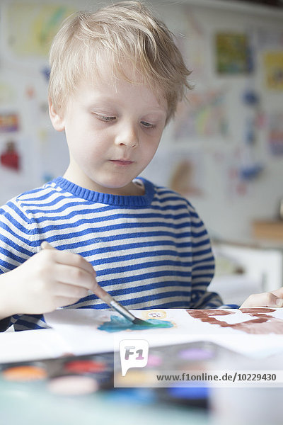 Porträt eines blonden kleinen Jungen mit Aquarellmalerei