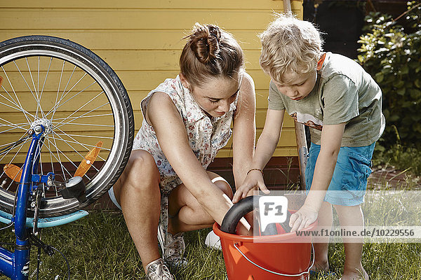 Mutter und Sohn reparieren gemeinsam das Fahrrad