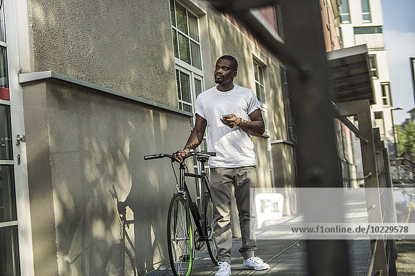 Portrait eines jungen Mannes mit Fahrrad