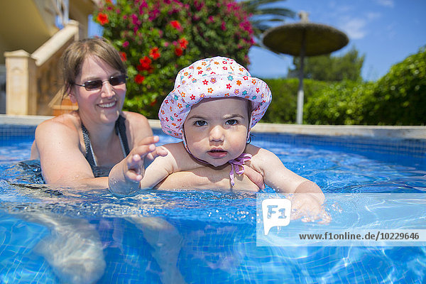 Spain  Mallorca  mother and her little daughter together in a swimming pool