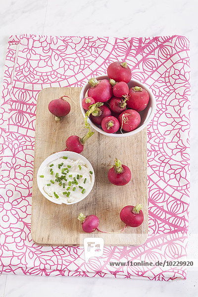 Bowl of red radishes and bowl of sour cream dip