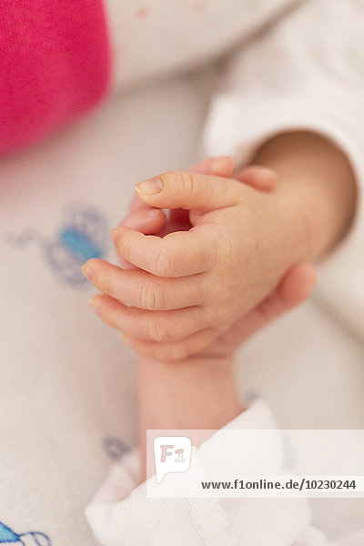 Newborn twins sleeping hand in hand  close-up