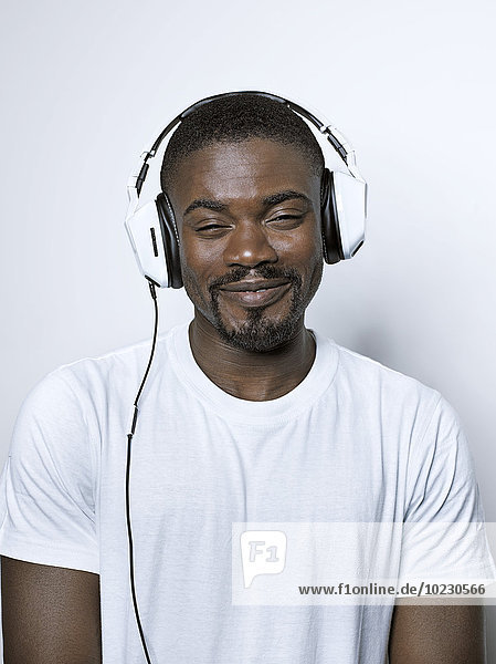 Porträt eines lächelnden jungen Mannes mit Kopfhörer
