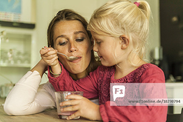 Daughter feeding mother with spoon