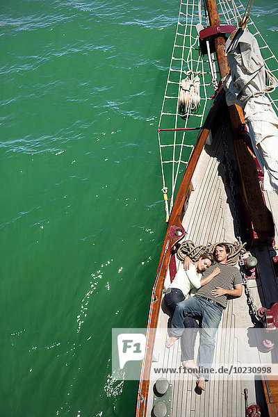 Entspanntes reifes Paar auf dem Deck eines Segelschiffes liegend