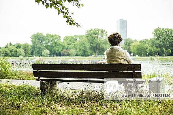 Back view of senior woman sitting on a bench