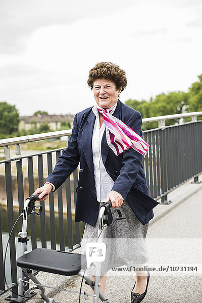 Smiling senior woman walking with wheeled walker