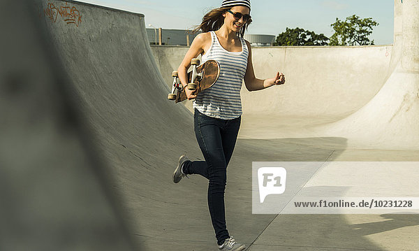 Young skate boarder running in a skatepark