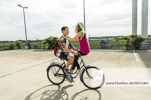 Glückliches junges Paar zusammen auf dem Fahrrad
