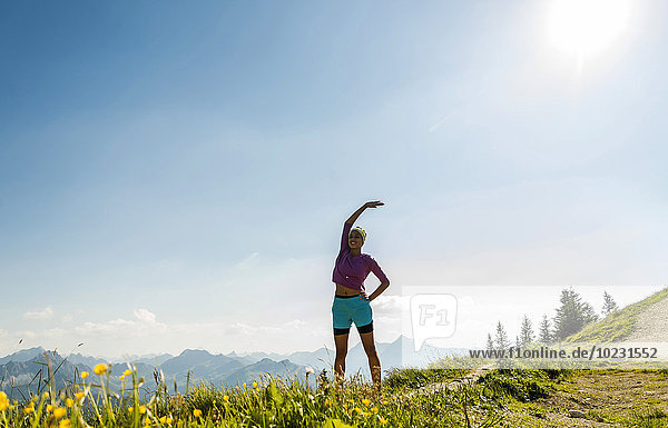 Austria  Tyrol  Tannheim Valley  young woman exercising in mountains