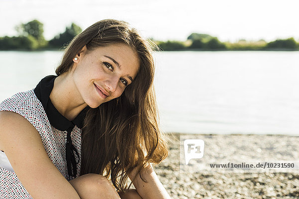 Portrait of smiling young woman by the riverside