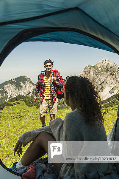 Austria  Tyrol  Tannheimer Tal  young couple camping on alpine meadow
