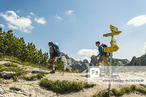 Austria  Tyrol  Tannheimer Tal  young couple hiking on mountain trail