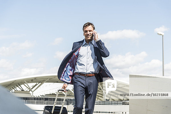 Businessman on business trip arriving with trolley