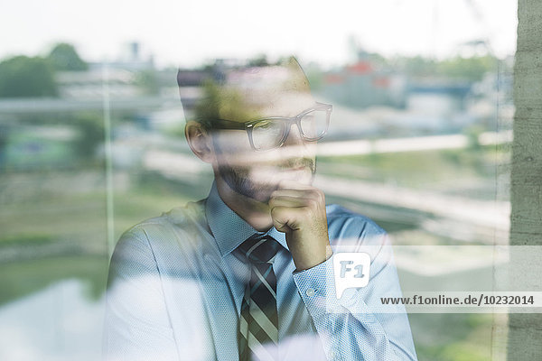 Young businessman looking out of window