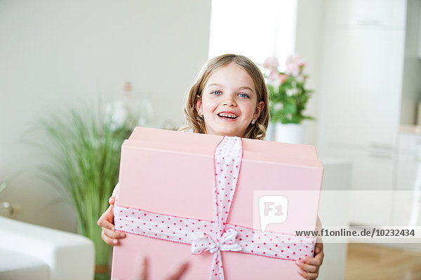 Little girl carrying gift box