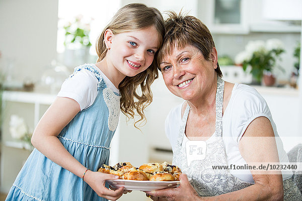 Großmutter und Enkelin in der Küche mit Gebäckteller