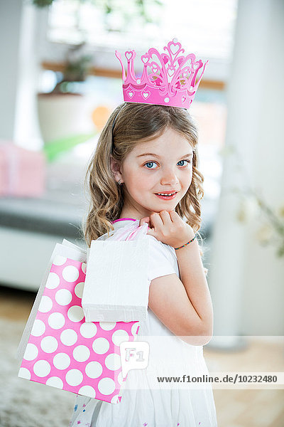 Mädchen in rosa Krone mit Geschenktüten