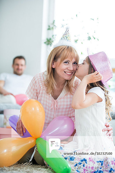 Familienfeier mit Luftballons und Partyhüten