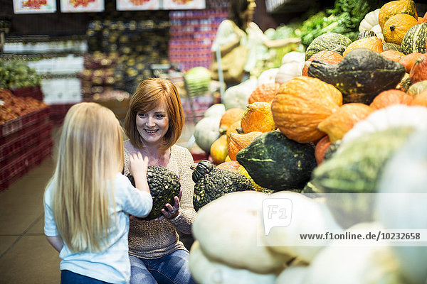 Mutter und Tochter im Supermarkt beim Einkaufen von Gemüse