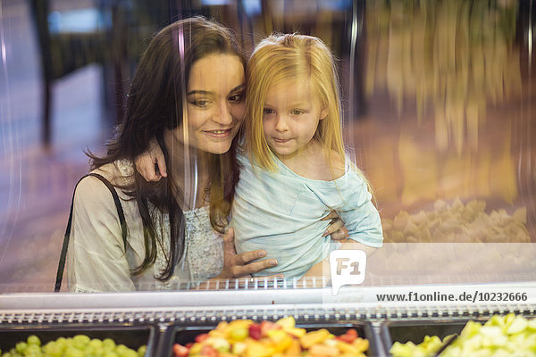 Mutter und Tochter beim Anblick des Obstsalats im Supermarkt