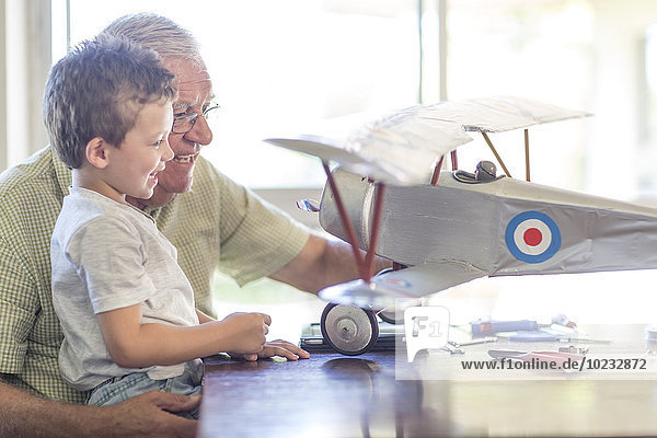 Großvater und Enkel beim Aufbau eines Modellflugzeugs