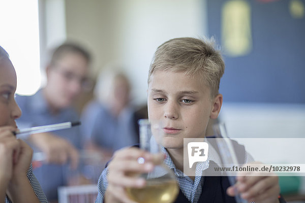 Schüler in der Chemieklasse mit Blick auf Rundkolben
