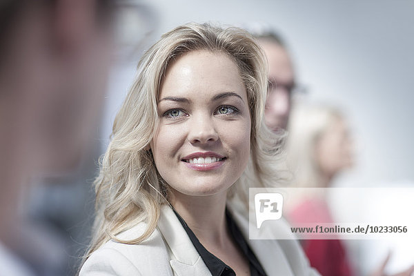Portrait of smiling young woman face to face with a colleague