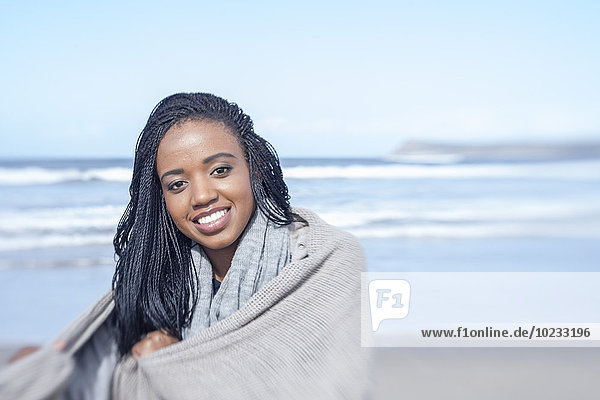 South Africa  Cape Town  portrait of smiling young woman in front of the sea