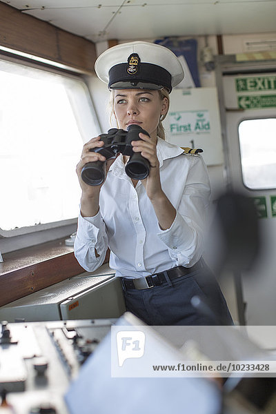 Deck officer on ship holding binoculars